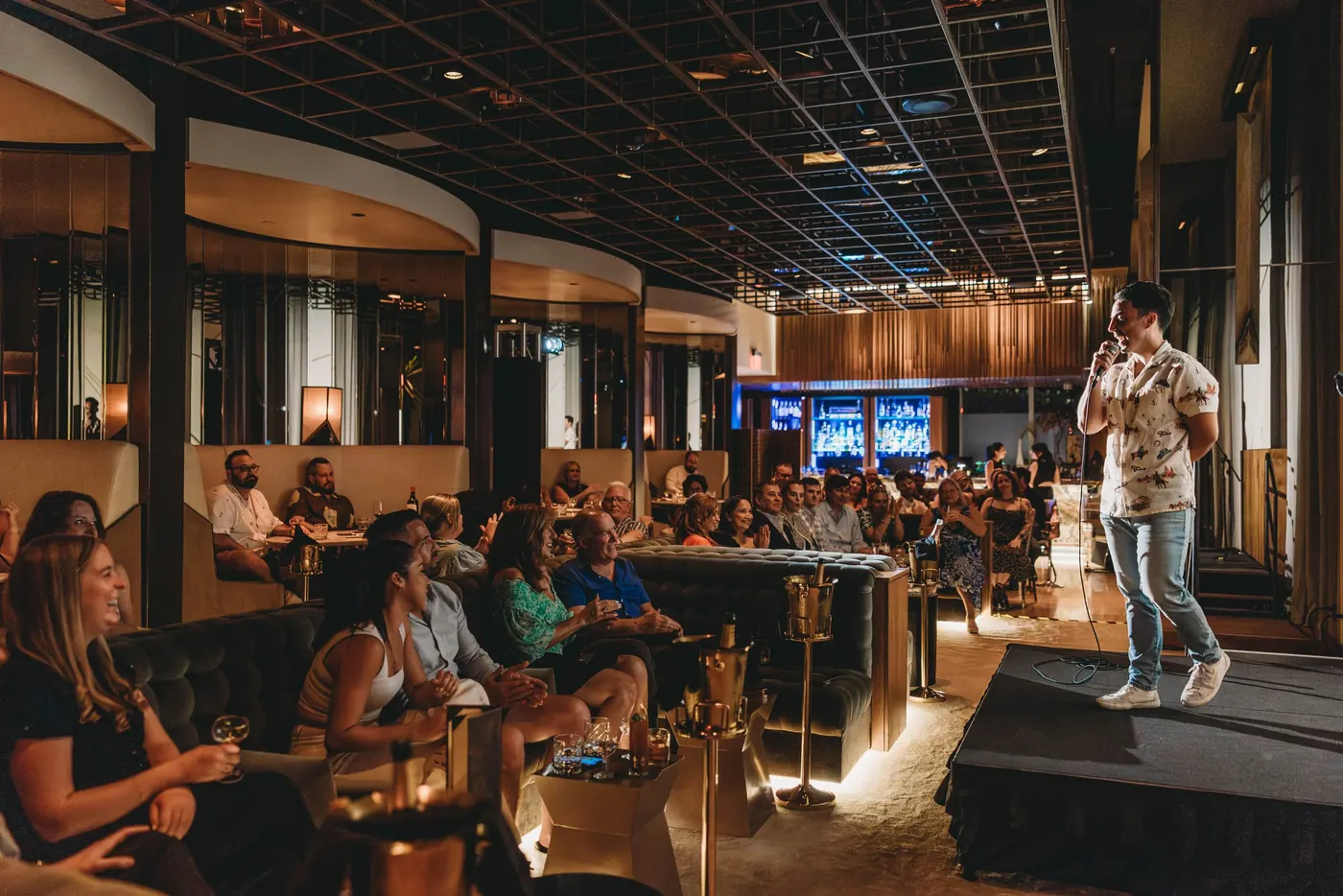 Evan Lopez on stage at a packed Top Flight Comedy show in Austin, Texas